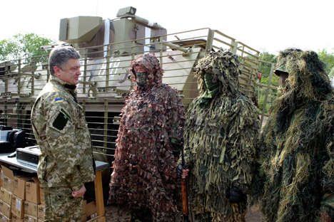 The Kommersant daily writes that the Ukrainian Army, on the orders of President Petro Poroshenko (left), has resumed its offensive in the east. Source: AP