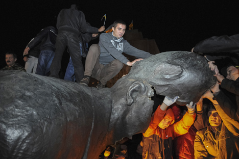 People react after a statue of Soviet state founder Vladimir Lenin was toppled by protesters during a rally organized by pro-Ukraine supporters in the centre of the eastern Ukrainian town of Kharkiv September 28, 2014. Source: Reuters