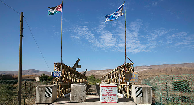 National Jordanian and Israeli flags are seen on the Naharayim bridge on the border between Israel and Jordan north-eastern Israel October 22, 2014. Source: Reuters