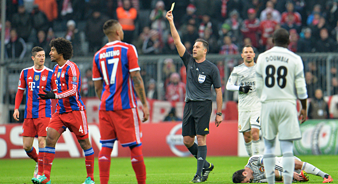 Bayern's Dante from Brazil, second left, is booked by referee Olegario Benquerenca after he fouled CSKA's Alan Dzagoev, right, during the Champions League group E soccer match between FC Bayern Munich and CSKA Moscow in Munich, Germany, Wednesday, Dec. 10, 2014. Source: AP