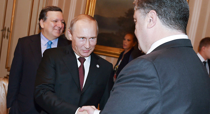 Russia's President Vladimir Putin (L) shakes hands with Ukraine's President Petro Poroshenko as he arrives for a meeting on October 17, 2014. Source: Reuters