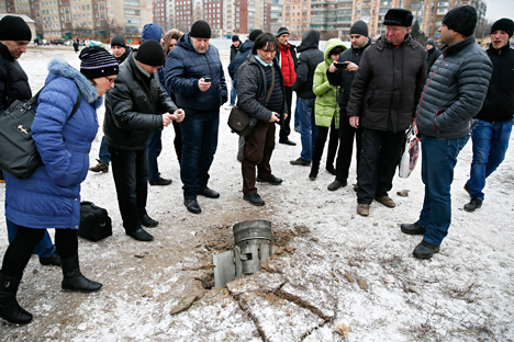  People look at the remains of a rocket shell on a street in the town of Kramatorsk, eastern Ukraine February 10, 2015. Three people were killed and 15 wounded in the rocket strike on the town of Kramatorsk on Tuesday, the government-controlled regional administration said in a statement. Source: Reuters