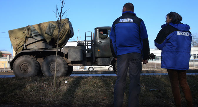 OSCE officials watch Grad multiple-launch rocket systems being withdrawn by Donetsk People's Republic troops from the outskirts of Donetsk. Source: Valery Sharifulin / TASS 