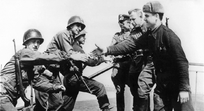 American (left) and Russian soldiers shake hands on April 24, 1945 at the destroyed bridge over river Elbe as both troops meet at Torgau, Germany. Source: DPA/AFP/East-News