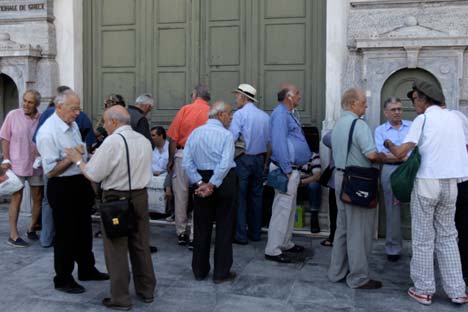 People, mostly pensioners who do not own an ATM card, wait in line outside a National Bank of Greece branch, in Athens, Greece, 29 June 2015. Source: EPA / Orestis Panagiotou
