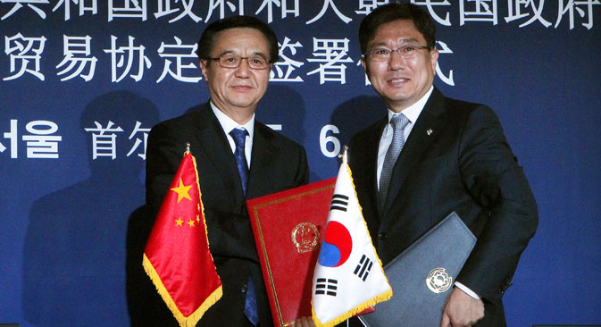 Chinese Commerce Minister Gao Hucheong, left, poses with his South Korean counterpart Yoon Sang-jick after signing documents for FTA or Free Trade Agreement during a signing ceremony in Seoul, South Korea. Source: AP