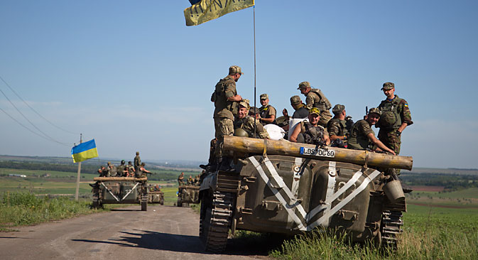 Ukrainian servicemen ride on an armored military vehicle not far from the city of Artemyevsk in the Donetsk region, June 9, 2015. Source: EPA