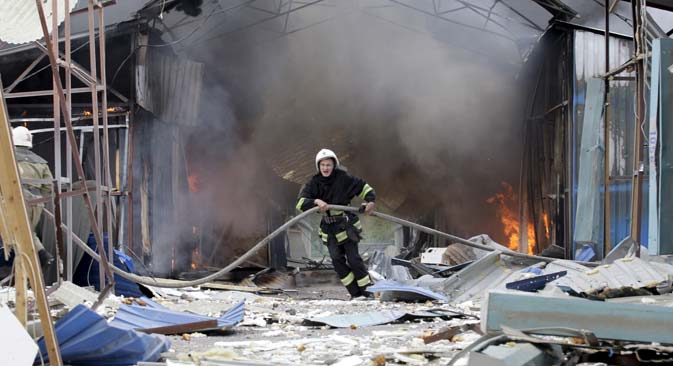 A firefighter works to extinguish a fire at a local market, which was recently damaged by shelling, in Donetsk, Ukraine, June 3, 2015. Source: AP