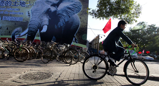 A man cycles past a billboard which promotes the China-Africa summit meeting on a street in Beijing. Source: AP/ Greg Baker