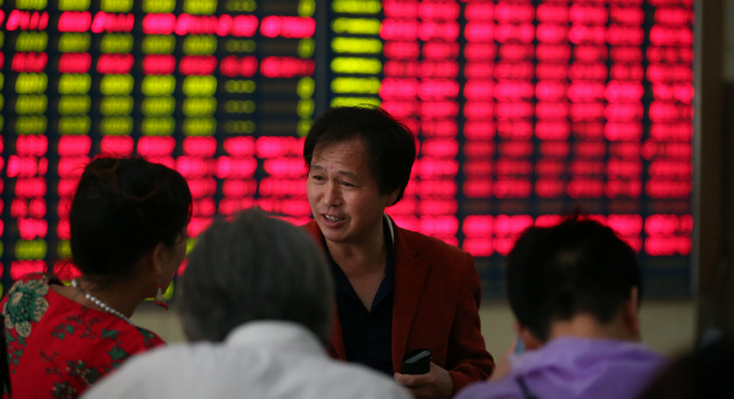 An investor talks with the others at a stock exchange in Nantong , Jiangsu province, China on 9th July 2015. Source: Vostock photo
