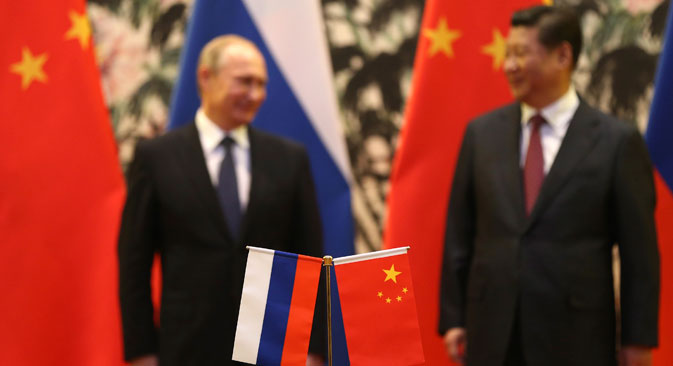 Russian and Chinese national flags are seen on the table with Russian President Vladimir Putin (L) and his Chinese counterpart Xi Jinping (R), Beijing, November 9, 2014.