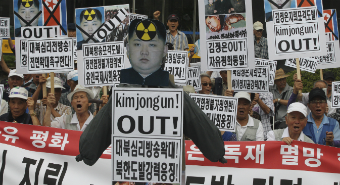 South Korean protesters with defaced portraits of North Korean leader Kim Jong Un and North Korean flags shout slogans during an anti-North Korean rally in Seoul, South Korea, Friday, Aug. 21, 2015. 