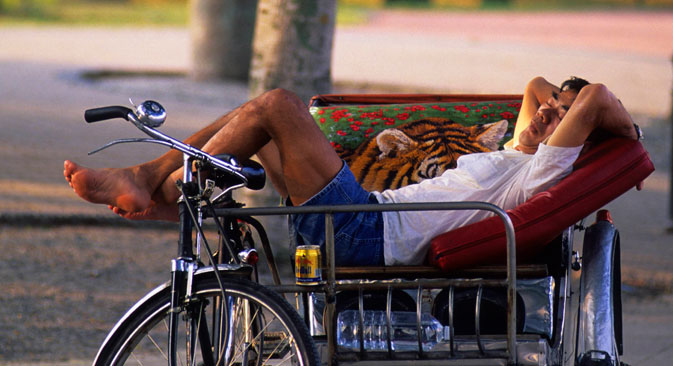 A man sleeping in a rickshaw in Esplanade Park, Singapore. Source: Photoshot/Vostock Photo