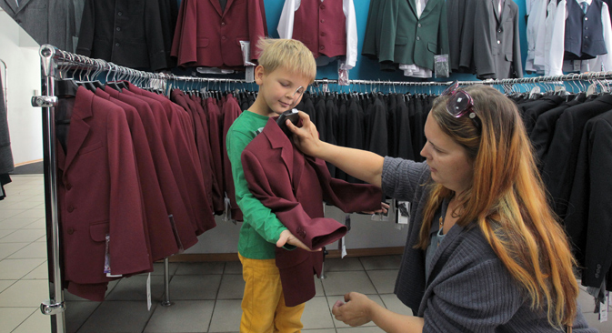 Children and their parents choose a new school uniform. Source: Petr Kovalev / TASS