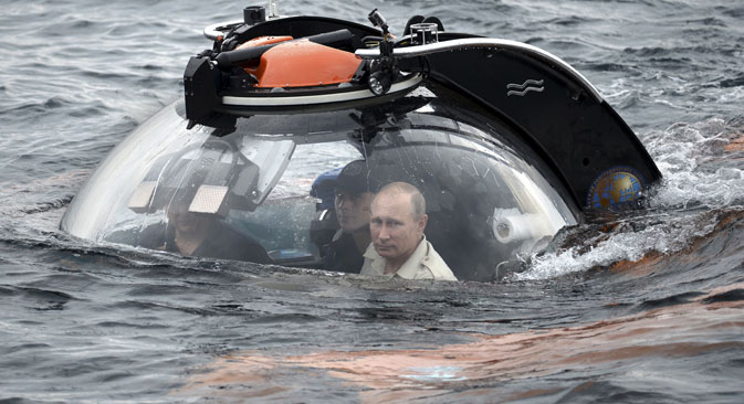 Russian President Vladimir Putin (R) looks through a window of a research bathyscaphe while submerging into the waters of the Black Sea as he takes part in an expedition near Sevastopol, Crimea, August 18, 2015. Source: RIA Novosti/ Kremlin