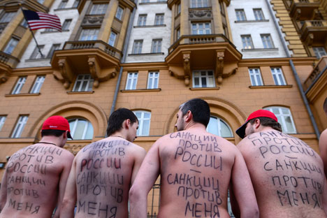Protesta frente a la embajada de EE UU en Moscú. En las espaldas se lee: "Las sanciones contra Rusia, son sanciones contra mí". Fuente: Ria Novosti / Evgueni Biiatov