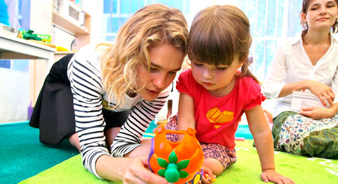Natalja Wodjanowa spielt mit dem Mädchen im Kinderzentrum der Stadt Krymsk, stark betroffen von der Überschwemmung im Sommer 2012.  Foto: Vera Kostamo/RIA Novosti