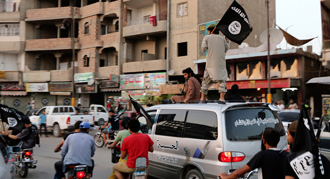 Les supporters de l'État islamique brandissent le drapeau de l'État islamique en Irak et au Levant. Crédit : Reuters