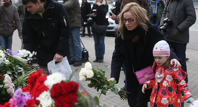 Des gens déposent des fleurs devant l'ambassade de France à Moscou. 