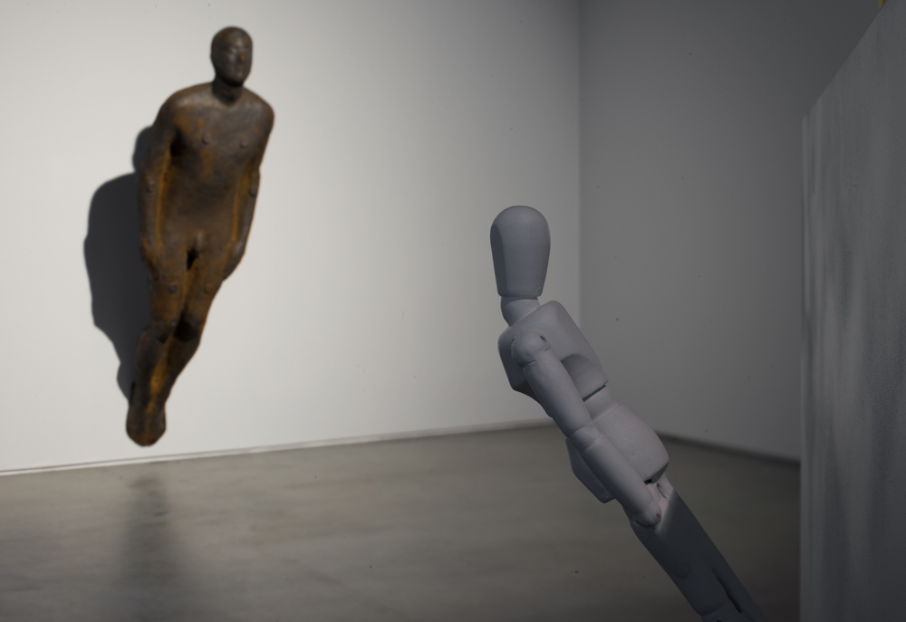 The naked bronze man by Antony Gormley and its plaster replica.