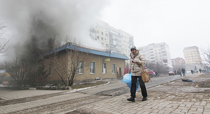 Stanovnica prolazi pored kuće koja gori u Mariupolju, Ukrajina.Izvor: AP