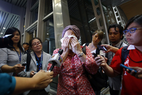 Jurnalis televisi mencoba mewawancarai seorang ibu yang tengah menangis menunggu kepastian kabar mengenai pesawat Malaysia Airlines MH17 yang ditembak jatuh di Ukraina. Foto: Reuters