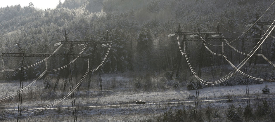 A car drives under high voltage power lines from Krasnoyarskhydroelectric power station, south of the Siberian city ofKrasnoyarsk, Russia, October 24, 2015. The 500-kilovolt line supplieselectricity to the Krasnoyarsk aluminium smelter and other industriesin Siberia.
