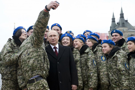 Presiden Rusia Vladimir Putin (tengah) ikut berfoto selfie dengan para anggota klub patriotik militer pemuda "Vympel" selama upacara peletakan karangan bunga di monumen Minin dan Pozharsky, dua orang pemimpin perjuangan kemerdekaan melawan penjajah asing pada tahun 1612, pada Hari Persatuan Nasional di Lapangan Merah, Moskow, Rusia, 4 November 2015. Rusia menandai Hari Persatuan Nasional pada 4 November untuk merayakan kekalahan penjajah Polandia pada tahun 1612.