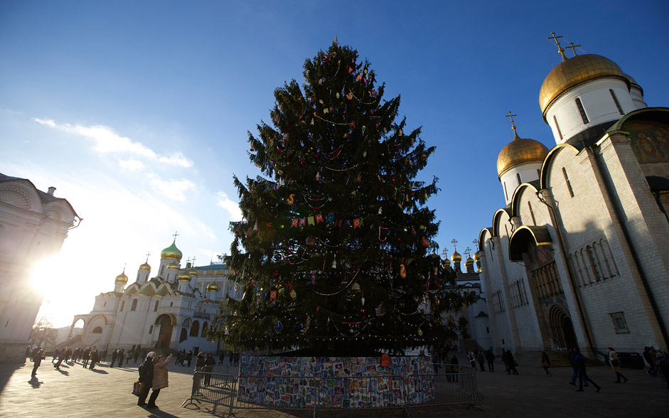 A New Year tree is installed for New Year and Christmas celebrations in Cathedral Square in the Kremlin in Moscow, Russia, on Tuesday, Dec. 29, 2015. Orthodox Christians celebrate Christmas on Jan. 7, in accordance with the Julian calendar. At right is the Assumption Cathedral.