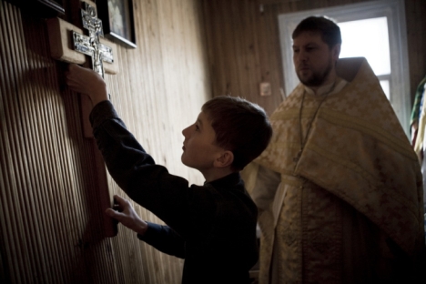 There is a simple greatness of daily life which can only be revealed far from big cities. Pictured: Fyodor helps to his father - Orthodox priest Roman - during the Sunday Service. Bagan Village, Novosibirsk Region, 2011. Source: Valery Klamm