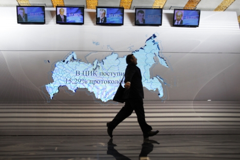 A man walks past a map of Russia and portraits of presidential candidates (L-R) Vladimir Zhirinovsky, Gennady Zyuganov, Sergei Mironov, Mikhail Prokhorov and Vladimir Putin at the Putin's headquarters in Moscow on March 4, 2012. Source: AP