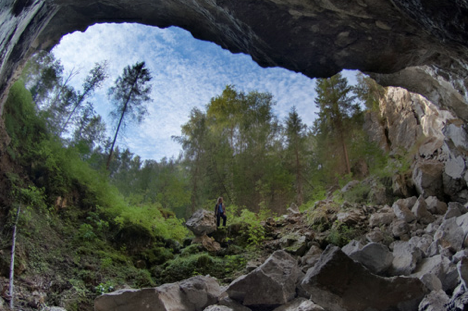 An expedition member standing at the opening of the Kungur Caves. Source: Viktor Lyagushkin / Getty Images