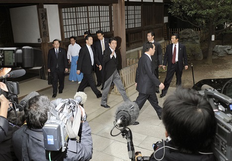 Prime Minister Shinzo Abe (raising hand) leaves Yasukuni Shrine in Tokyo on Dec. 26, 2013 after paying homage there. Source: Photoshot / Vostock-photo