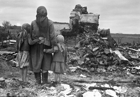 A woman and two girls looking at their destroyed house, USSR, 1943. Source: RIA Novosti