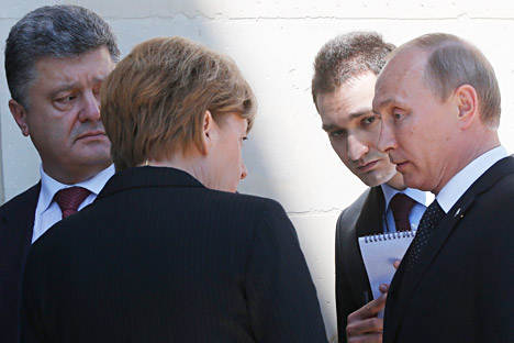 Angela Merkel, Vladimir Putin and Petro Poroshenko talk after a group photo as they take part in the 70th anniversary of D-Day in Benouville in Normandy, France, June 6, 2014. Source: AP