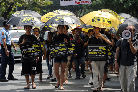 Filipino activists carrying umbrellas painted with slogans, march towards the Chinese consular office to show their support for Hong Kong pro-democracy protesters during a rally in the financial district of Manila on October 2, 2014. Source: AFP / East News