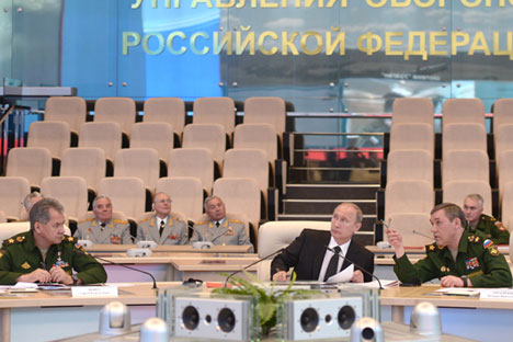 Vladimir Putin (c), Russian Defence Minister Sergei Shoigu (l) and Chief of the General Staff of the Russian Armed Forces Valery Gerasimov (r) at the National Defence Management Centre. Source: Alexey Nikolsky / RIA Novosti