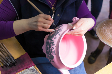 Gzhel artist at work on a vase at a Gzhel facility, manufacturing Russian folk art porcelain. Source: Lori/Legion Media