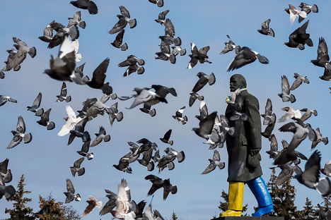 Pigeons fly around a monument of the Soviet state founder Vladimir Lenin painted in the colors of the Ukrainian national flag is seen in Kramatorsk, eastern Ukraine February 11, 2015. Source: Reuters