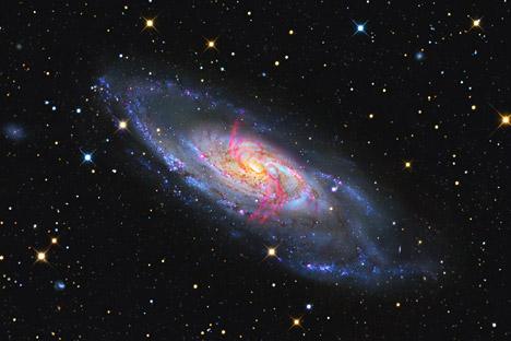 Seen in the light emitted by hydrogen molecules when they become ionized, these arms display an artificial red hue to make them visible in the image I produced. The extra arms are now believed to be caused by high energy jets emanating from an active 40 million solar mass super-massive black hole menacing the galaxy’s center. Source: GaBany / NASA