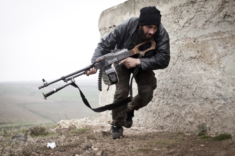 A Free Syrian Army fighter takes cover during fighting with the Syrian Army in Azaz, Syria.