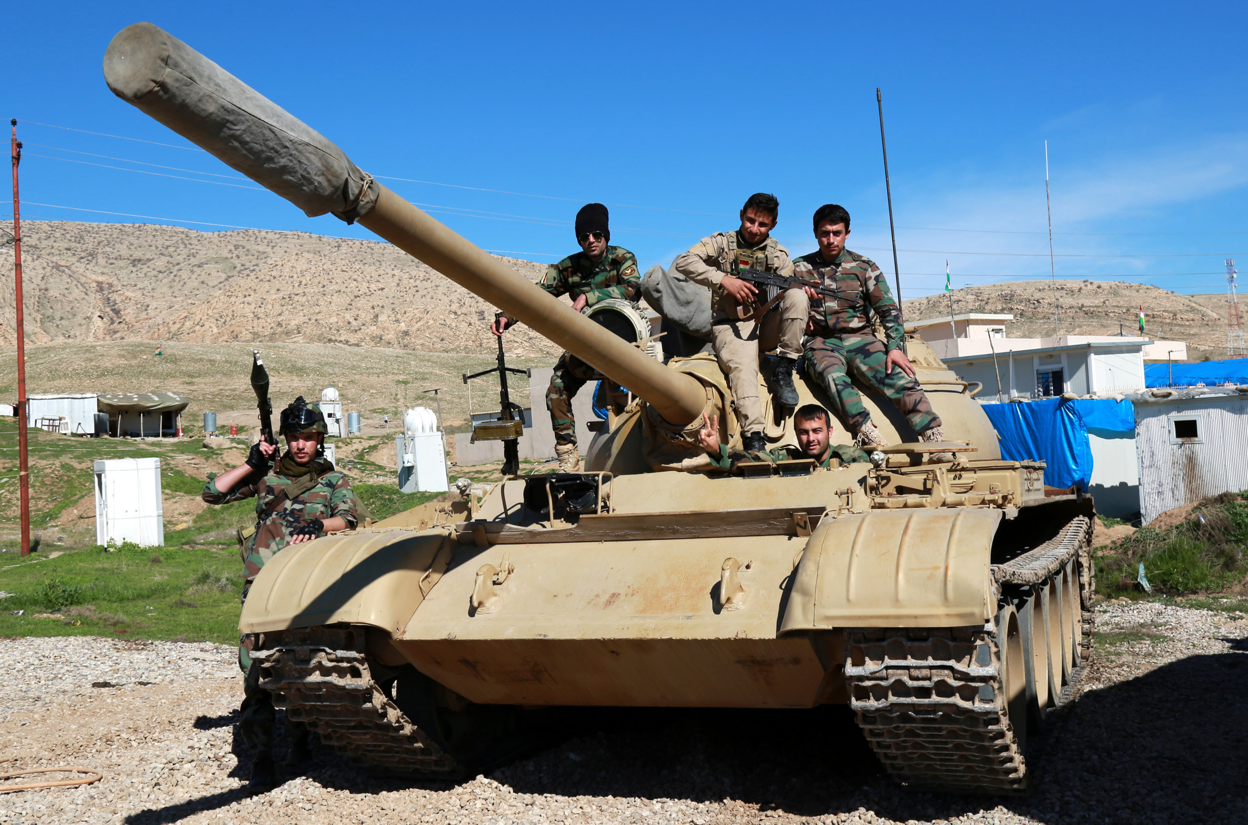 Iraqi Kurdish Peshmerga fighters pose for a photo atop a tank as they take up positions around the town of Basheqa, 150 Km northeast of Erbil, Iraq, 17 February 2016.