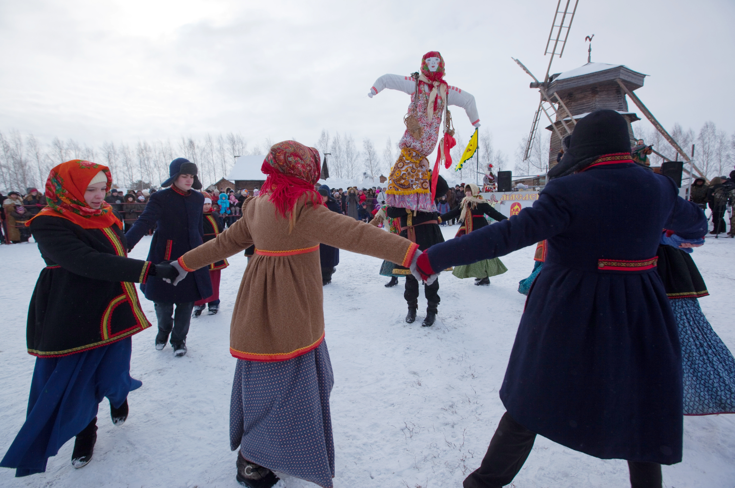 Suzdal residents sing and dance around Maslenitsa scarecrow during Maslenitsa celebration.