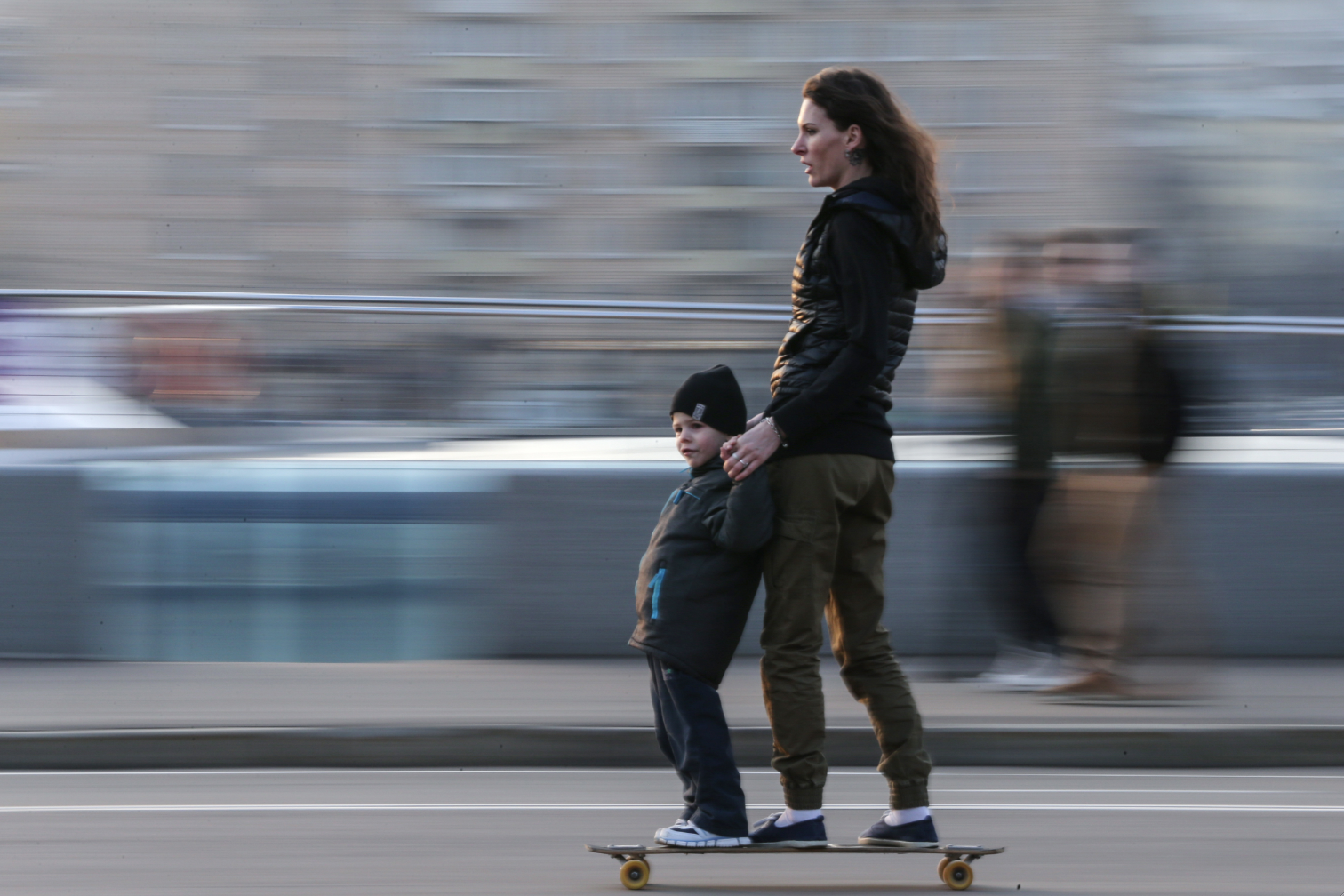 A woman and a kid skateboarding on Pushkinskaya Embankment in Moscow. 
