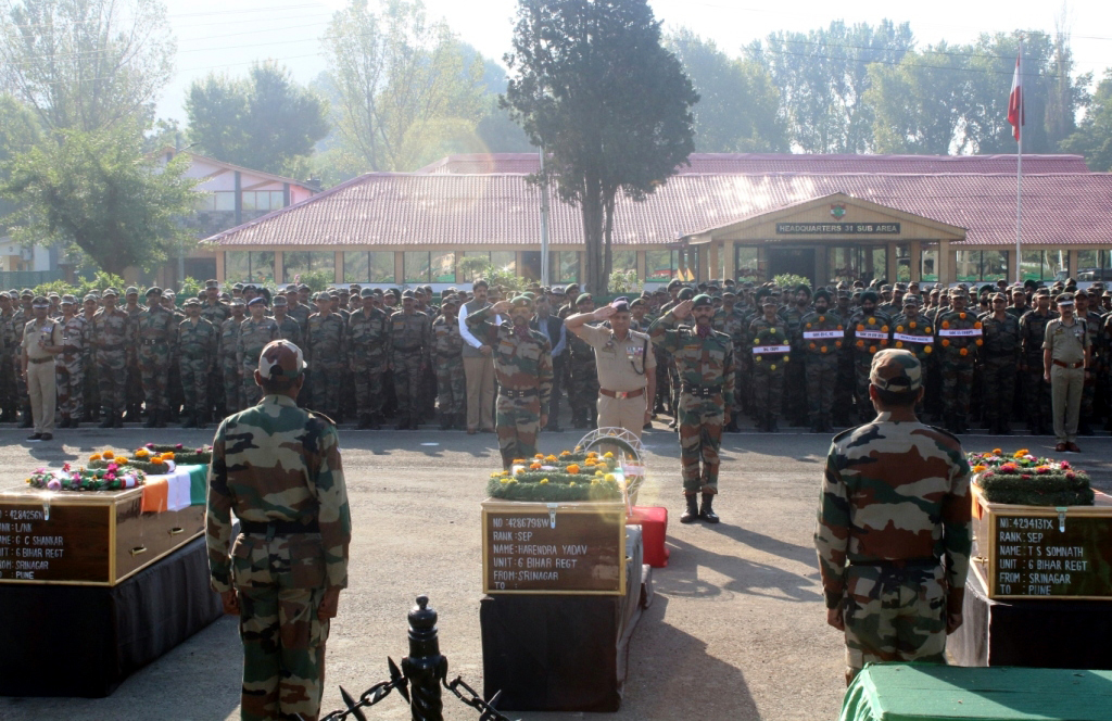 Director General of Jammu and Kashmir Police, K Rajendra Kumar (C) salutes near the coffins containing bodies of Army soldiers during a wreath laying ceremony at Badami Bagh Cantonment, the Indian Army's headquarters in Srinagar, 19 September 2016.