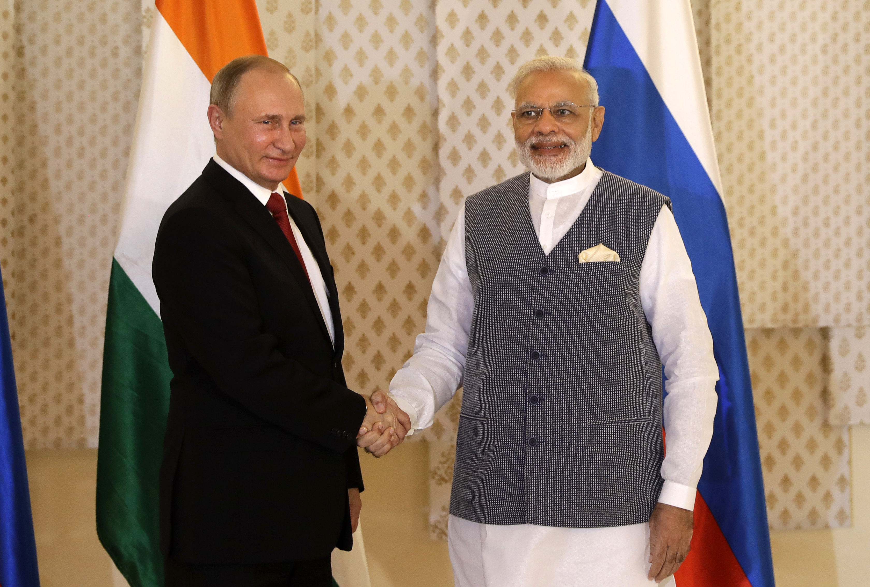 PM India Narendra Modi (kanan) berjabat tangan dengan Presiden Rusia Vladimir Putin menjelang pertemuan bilateral mereka di sela Konferensi BRICS di Goa, (15/10).