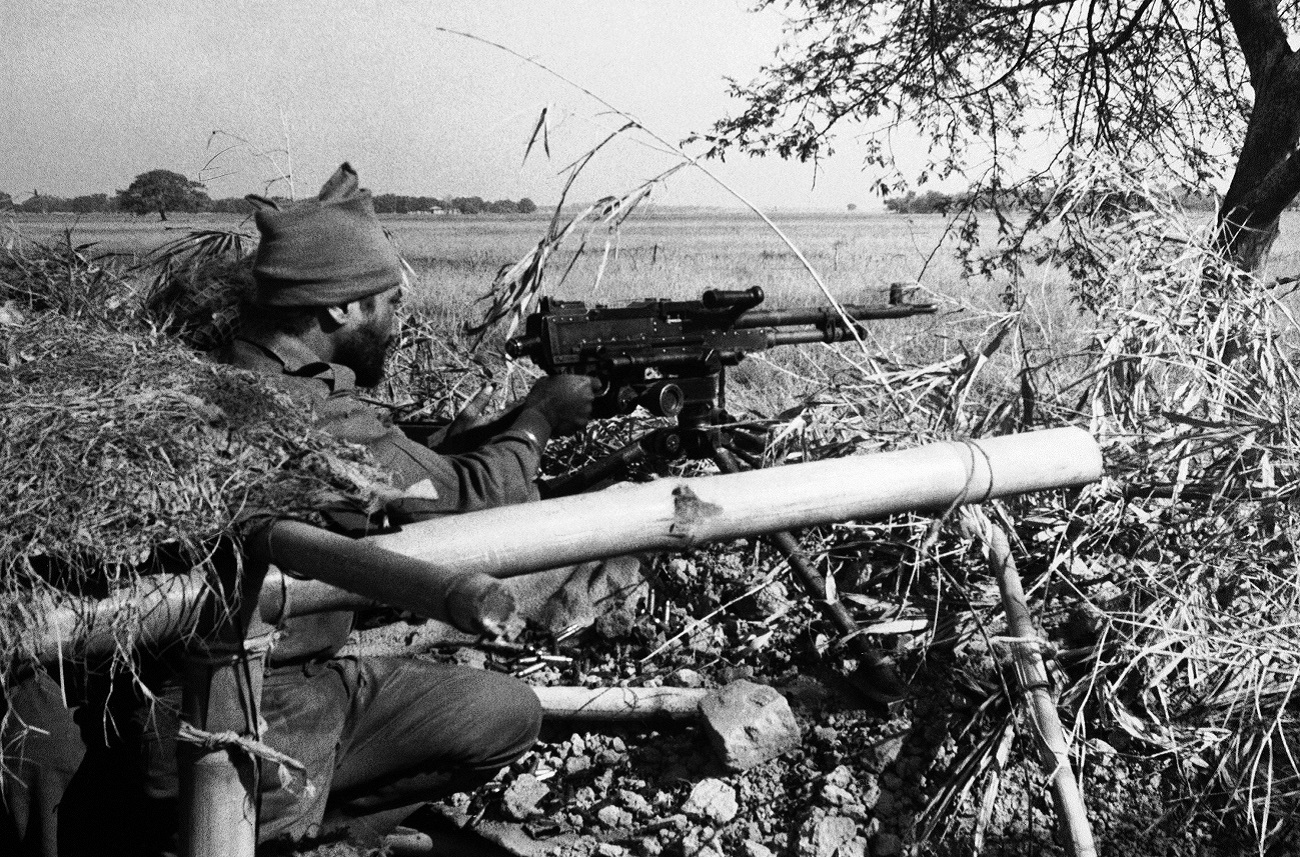 An Indian Army machine gunner fires at Pakistani positions in a village across an open field, 1,500 yards inside the East Pakistan border at Dongarpara on Dec. 7, 1971.