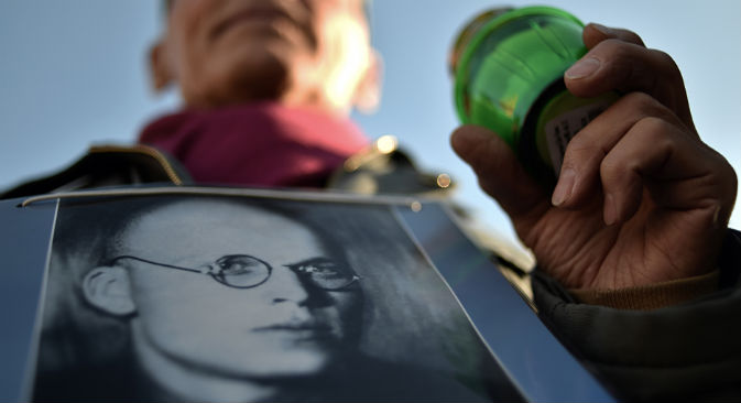 In occasione della manifestazione in memoria delle vittime, che si tiene tutti gli anni in Piazza Lubjanka a Mosca, un uomo regge il ritratto del padre morto durante il periodo della repressione politica (Foto: AFP/East News)
