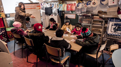 Дети на уроке в волонтерской школе в лагере для беженцев 