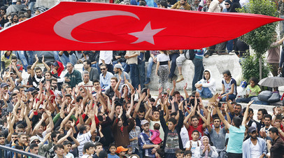 Толпа мигрантов из Сирии у главного автовокзала под турецким флагом в Стамбуле, Турция